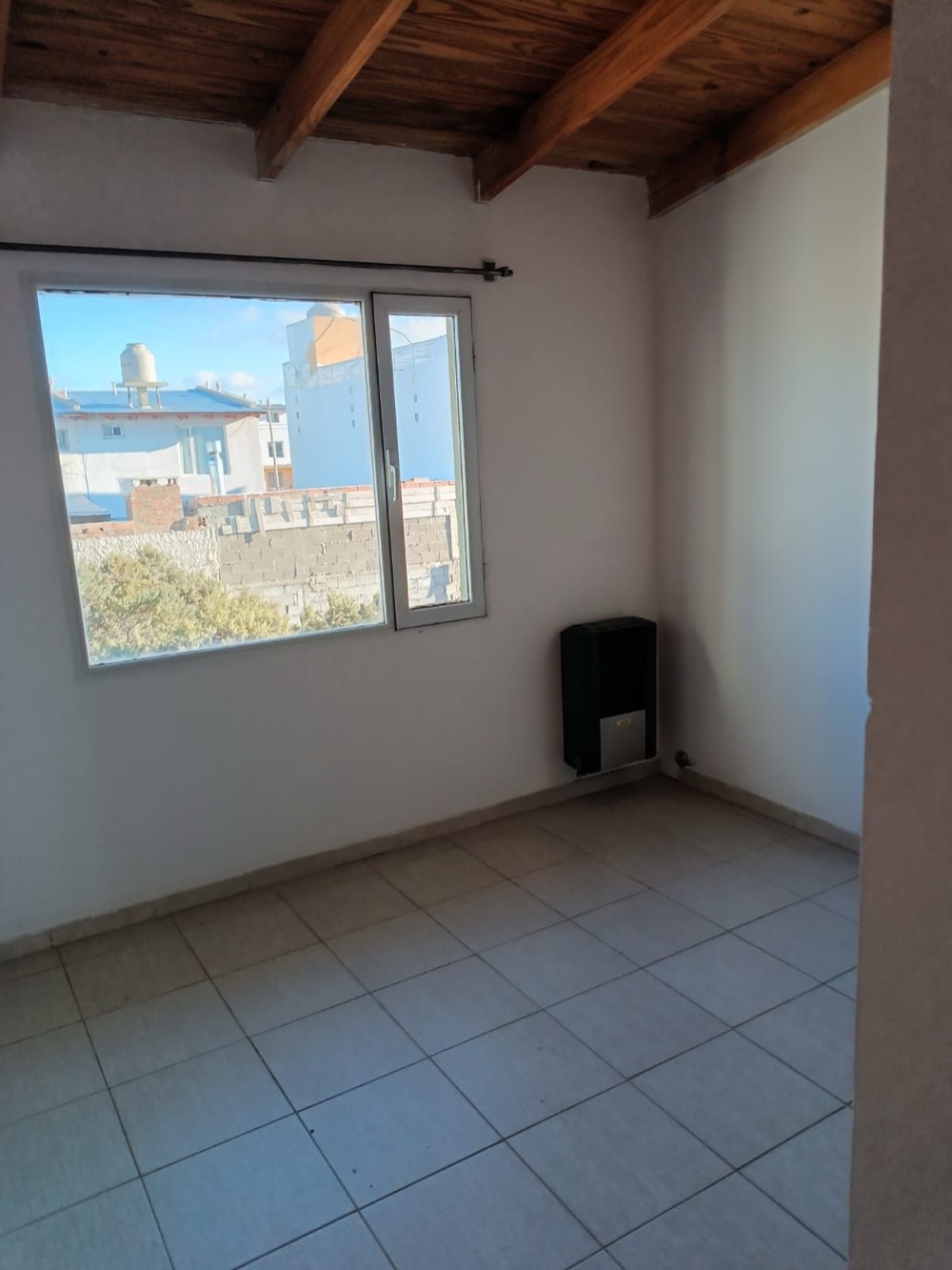 Dormitorio con ventana y calefactor