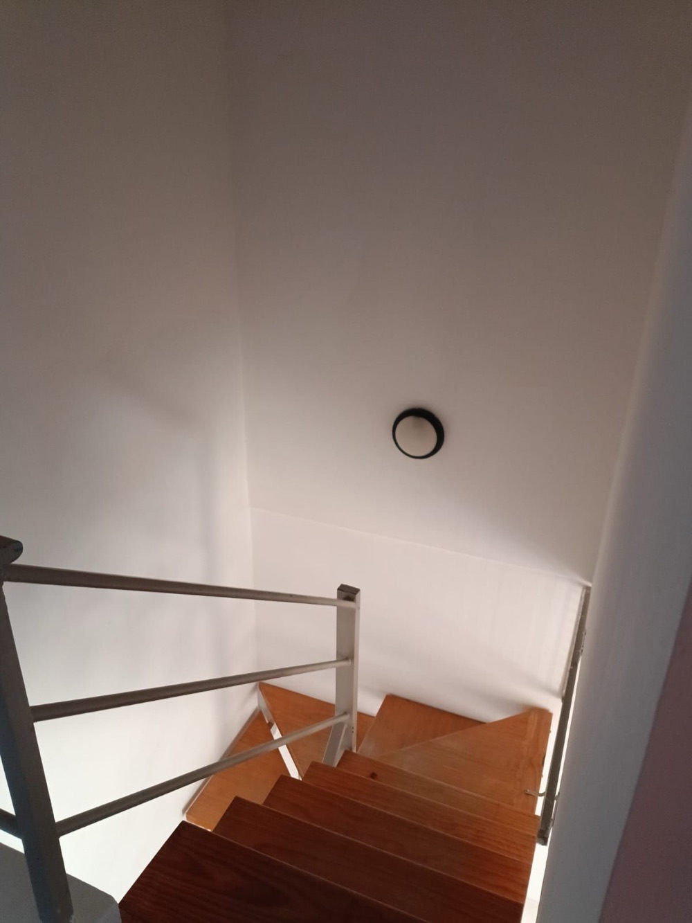 Escalera de madera con baranda metálica vista desde arriba